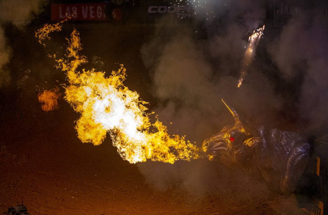 Flames erupt from a metal bull off the stage as cowboys are announced during opening ceremonies ...