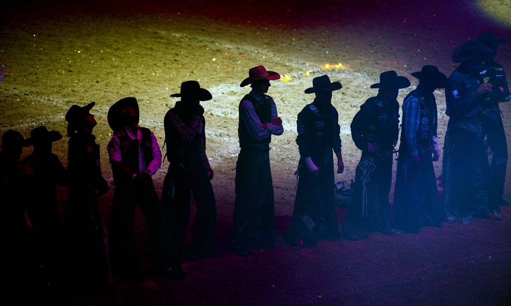 Cowboys line up while announced during opening ceremonies on the third day of the PBR World Fin ...