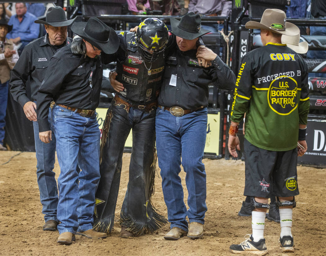 Cody Teel is assisted from the ring after riding with a torn ACL atop of Udder Lover during the ...