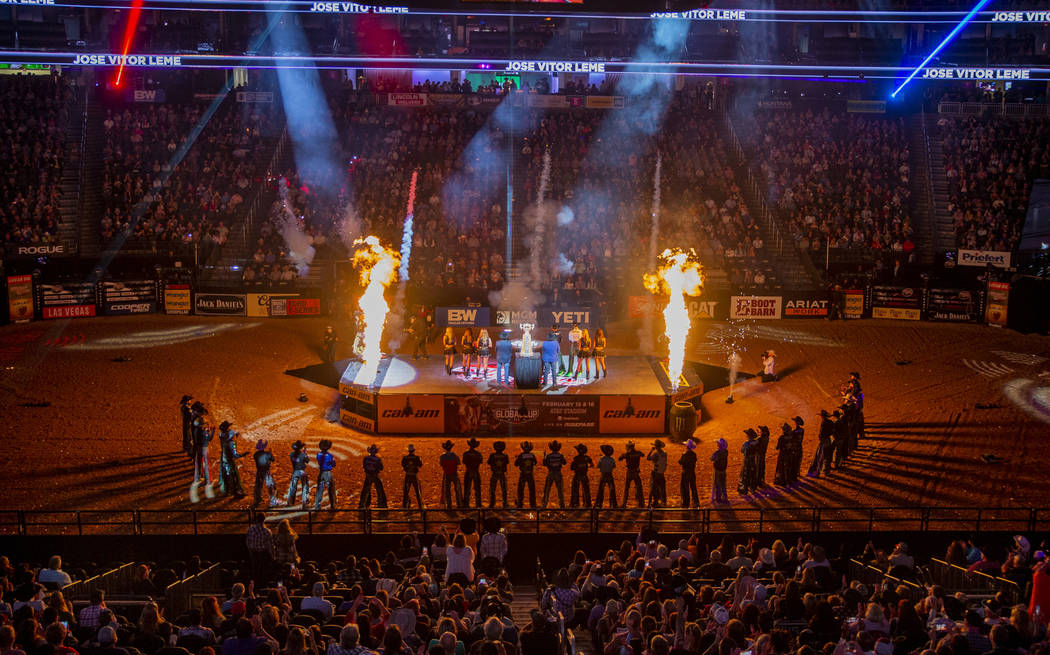 Riders are silhouetted by pyrotechnics during opening ceremonies on the last day of the PBR Wor ...