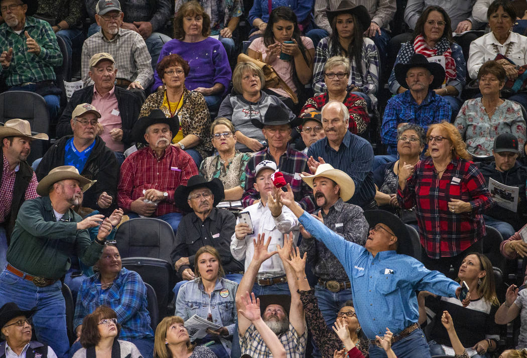 Fans reach for a free t-shirt tossed in to the crowd during the last day of the PBR World Final ...