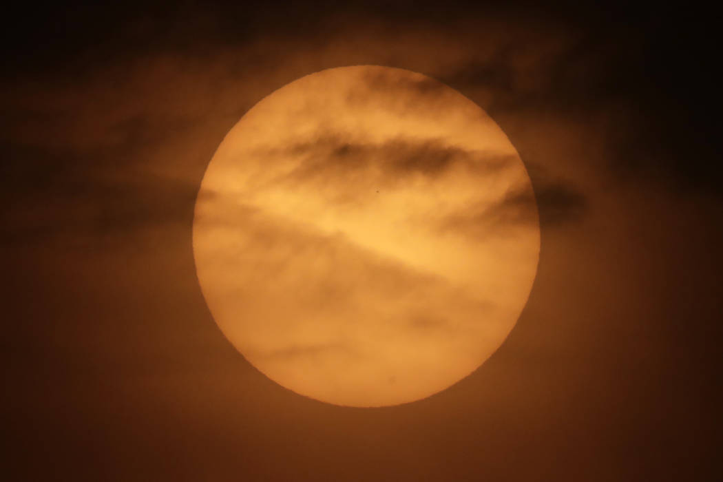 The planet Mercury is seen as a tiny dot above the mid-point of the sun during a transit across ...