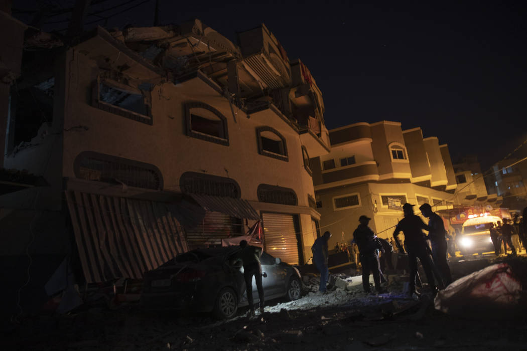 Palestinians check the damage of a house targeted by Israeli missile strikes in Gaza City, Tues ...