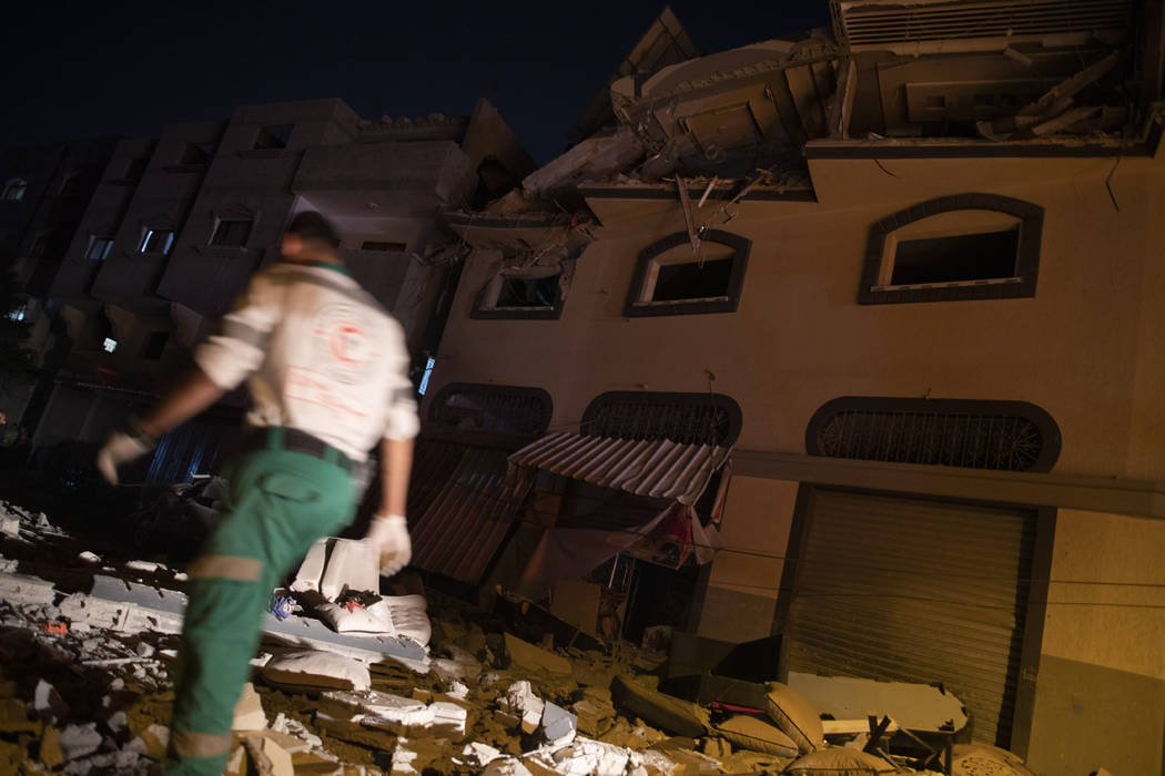 Palestinians check the damage of a house targeted by Israeli missile strikes in Gaza City, Tues ...