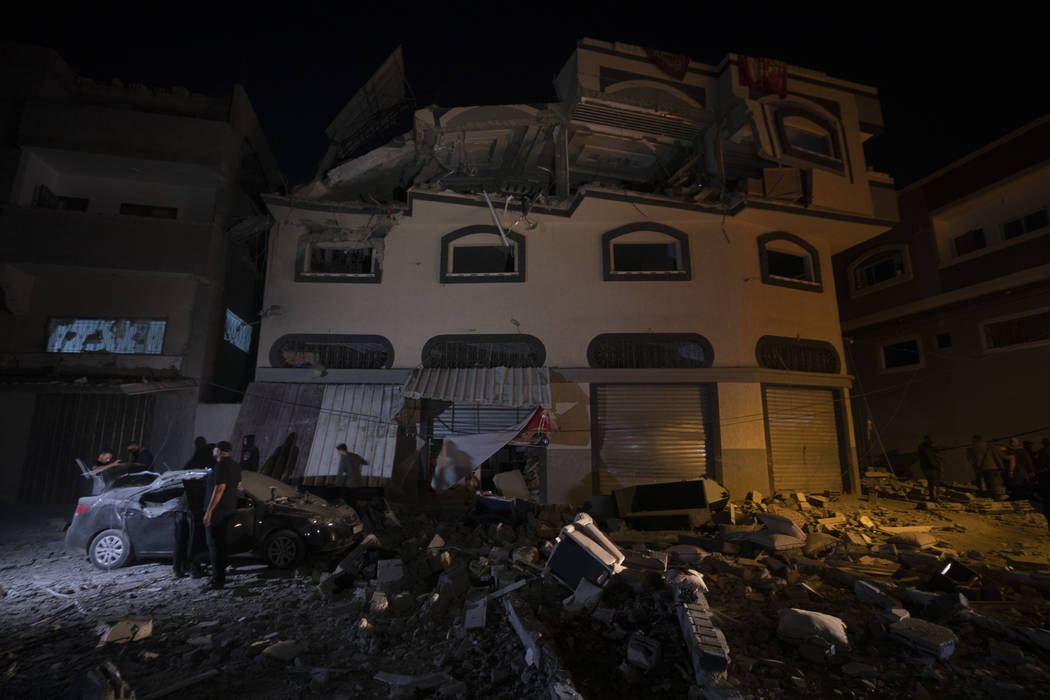 Palestinians check the damage of a house targeted by Israeli missile strikes in Gaza City, Tues ...
