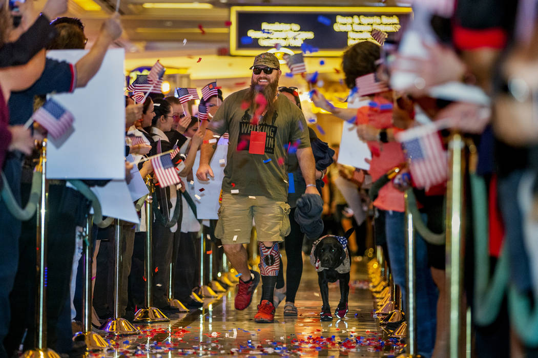 Wounded veteran Christopher Miller and his dog Zulu are celebrated as they make their way throu ...