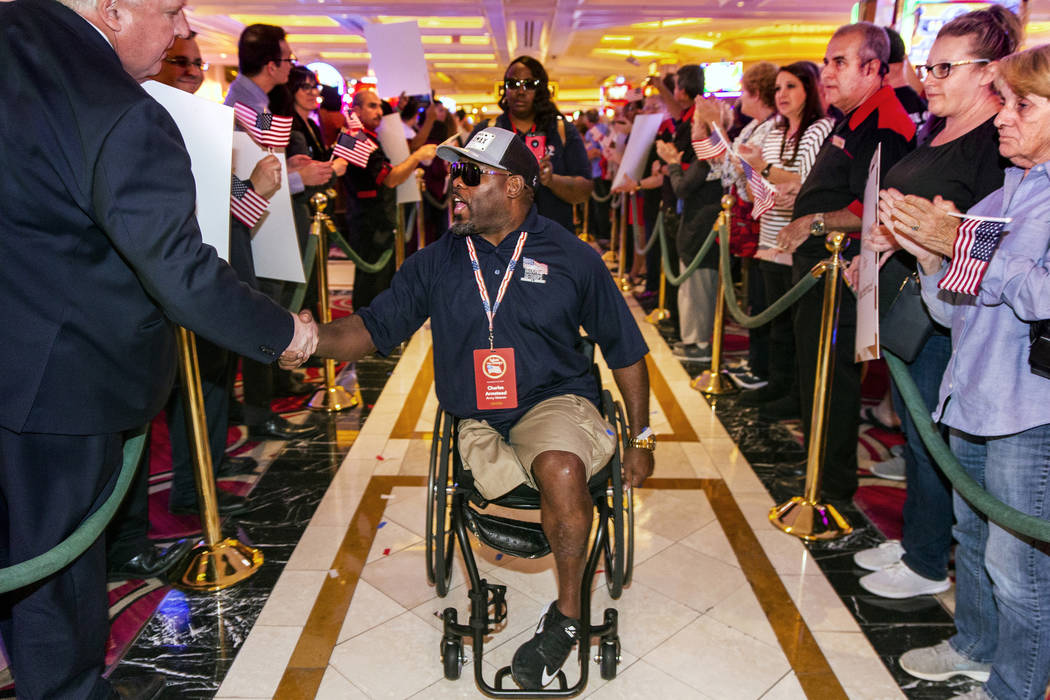 Wounded veteran Charles Armstead, center, is greeted and applauded as he makes his way through ...