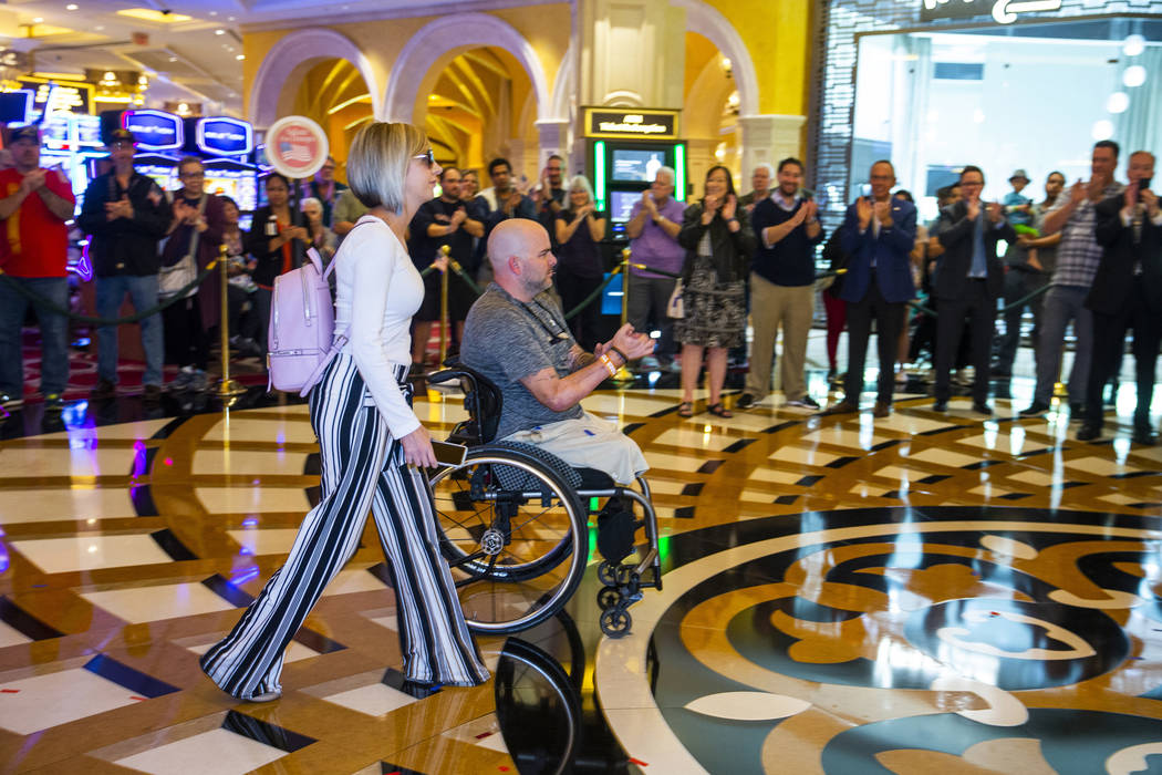 A wounded veteran, center, and family member are celebrated as they make their way through the ...