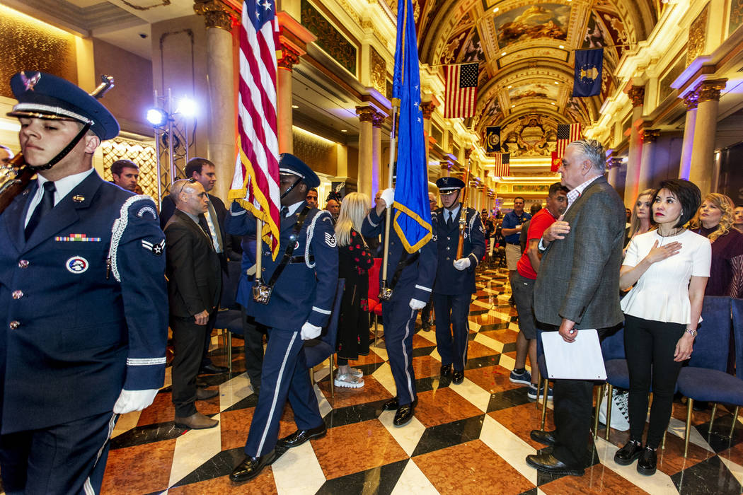 Members of the the Nellis Honor Guard bring in the colors before Gov. Steve Sisolak with his wi ...