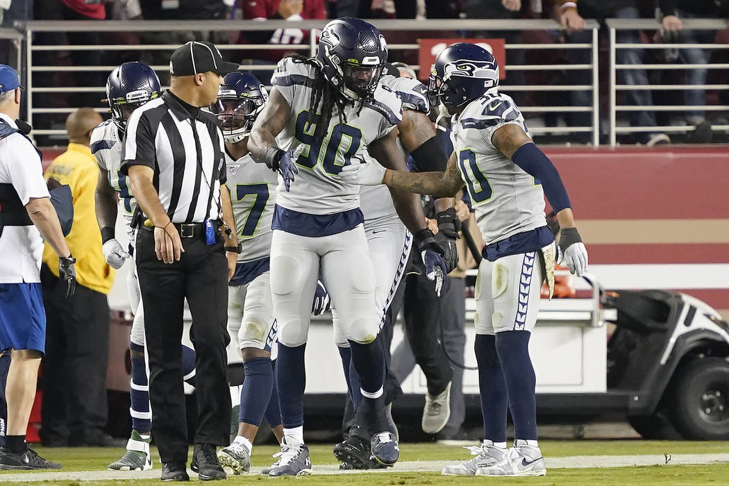 Seattle Seahawks defensive end Jadeveon Clowney (90) is congratulated by strong safety Bradley ...