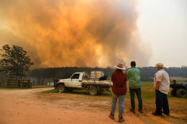 Locals watch smoke from a large bushfire outside Nana Glen, near Coffs Harbour, Tuesday, Nov. 1 ...