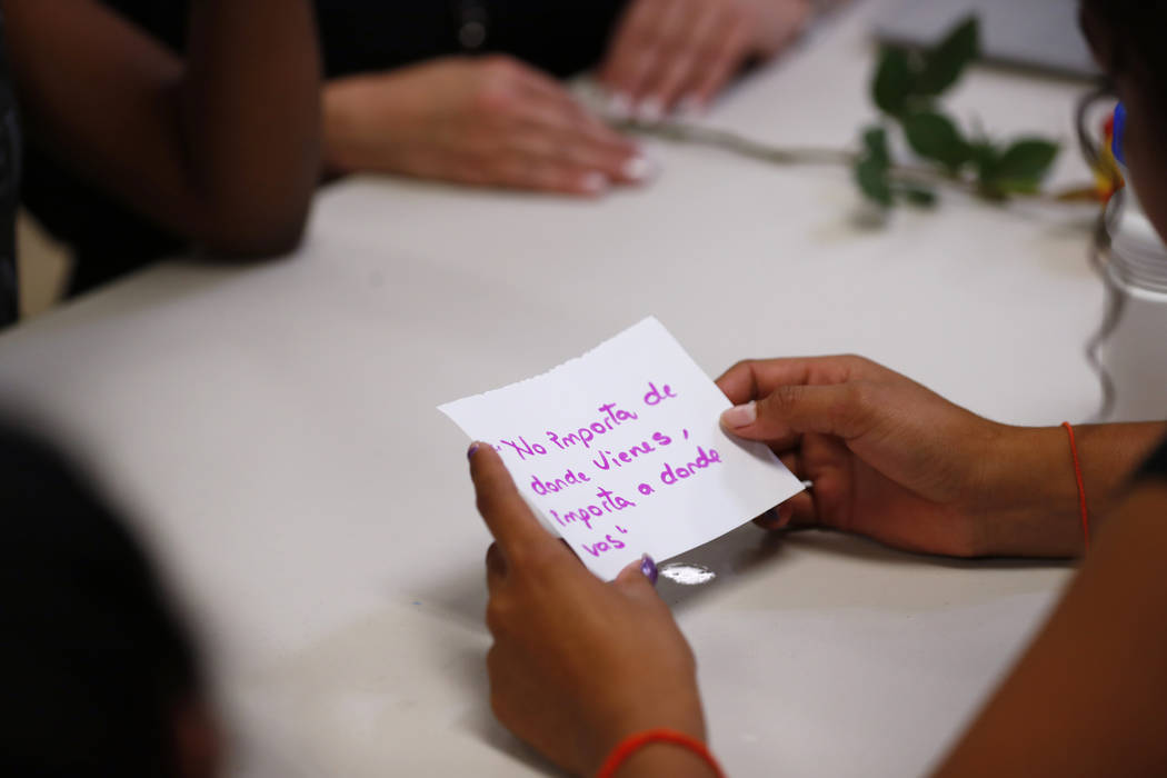 In this Sept. 24, 2019, photo, a migrant girl in U.S. government custody holds a card that says ...