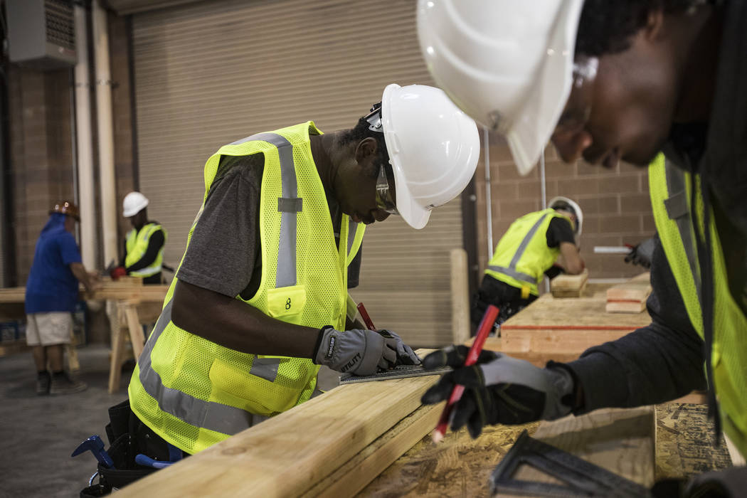 Tayvon Jenkins takes measurements in a framing class for homeless youth as part of HomeAid WORK ...