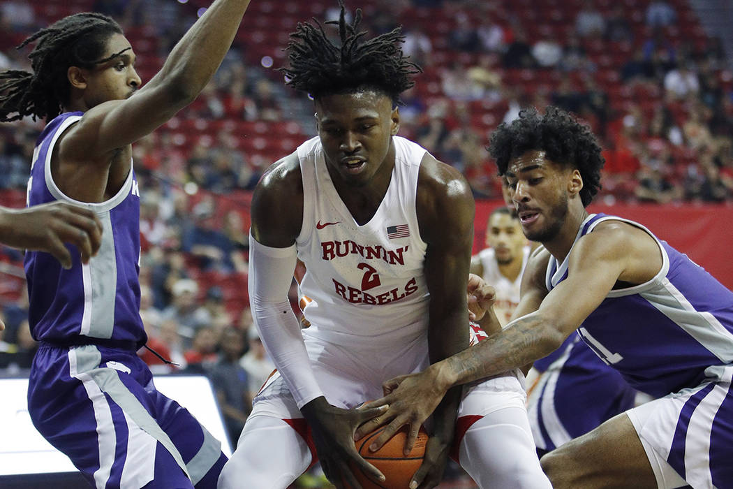 UNLV's Donnie Tillman, center, drives through Kansas State's Cartier Diarra, left, and Antonio ...