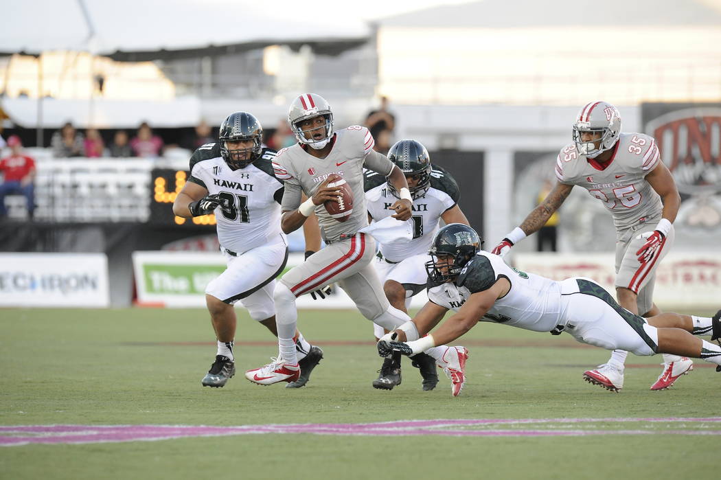 UNLV quarterback Caleb Herring runs away from Hawaii pass rushers in the Rebels' 39-37 victory ...