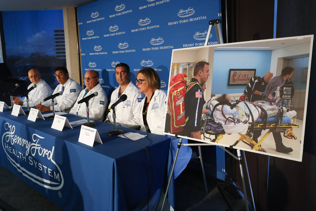 A photo of a patient being transported is displayed while medical staff at Henry Ford Hospital ...