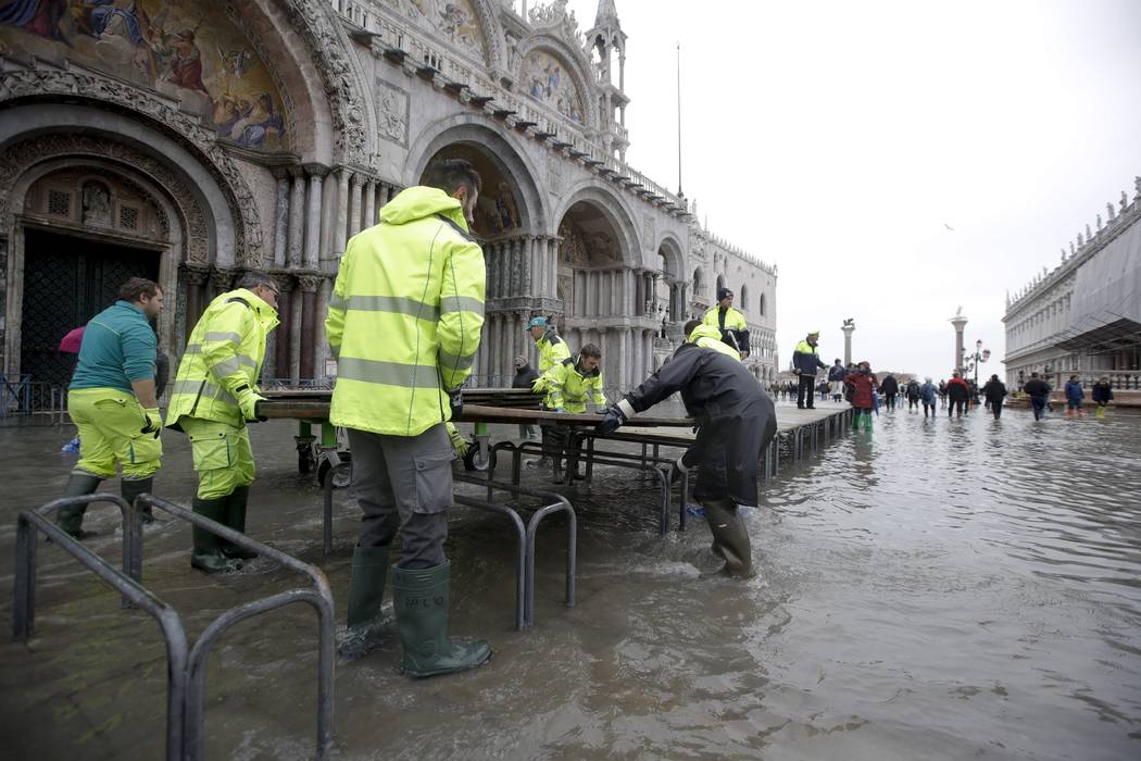 City council workers place catwalks in St. Mark's Square, in Venice, Wednesday, Nov. 13, 2019. ...