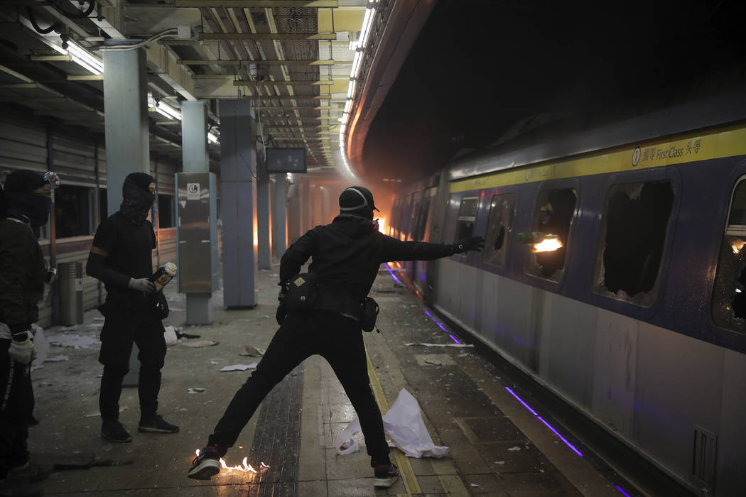 A student hurls a molotov cocktail into a train parked inside the Chinese University MTR statio ...