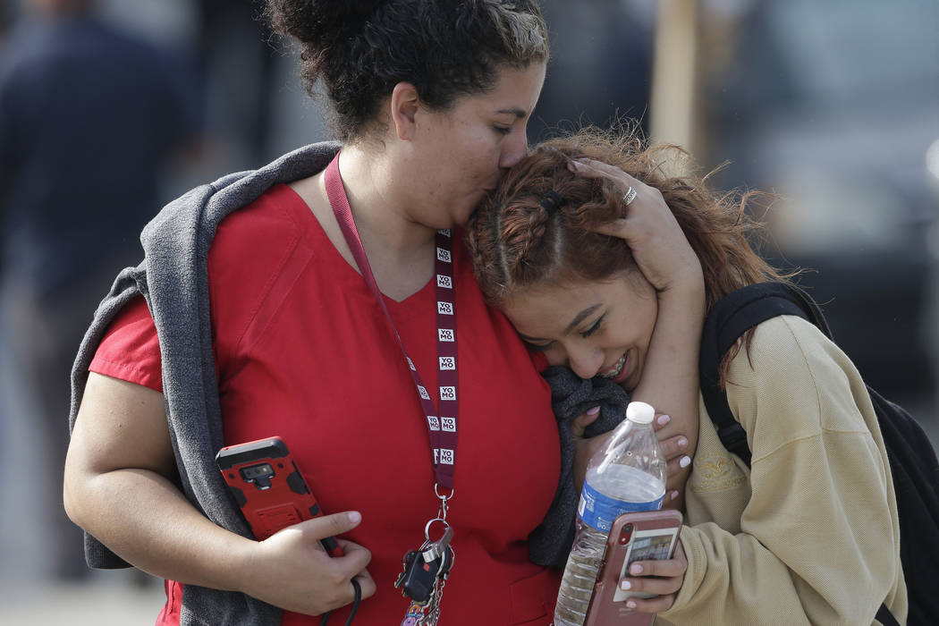 Parent Alicia Leon, left, kisses her daughter, Alejandra Cruz, a 10th grader, as they reunite a ...