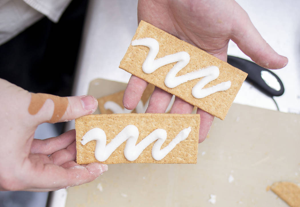 Aria Patisserie pastry chef Jake Broadbent works on a giant gingerbread house in the lobby of t ...