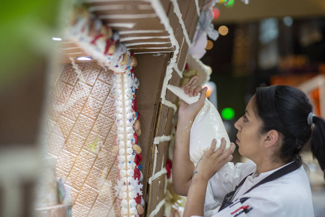 Patisserie assistant pastry chef Andrea Madrid Aria outlines gingerbread bricks with icing on t ...