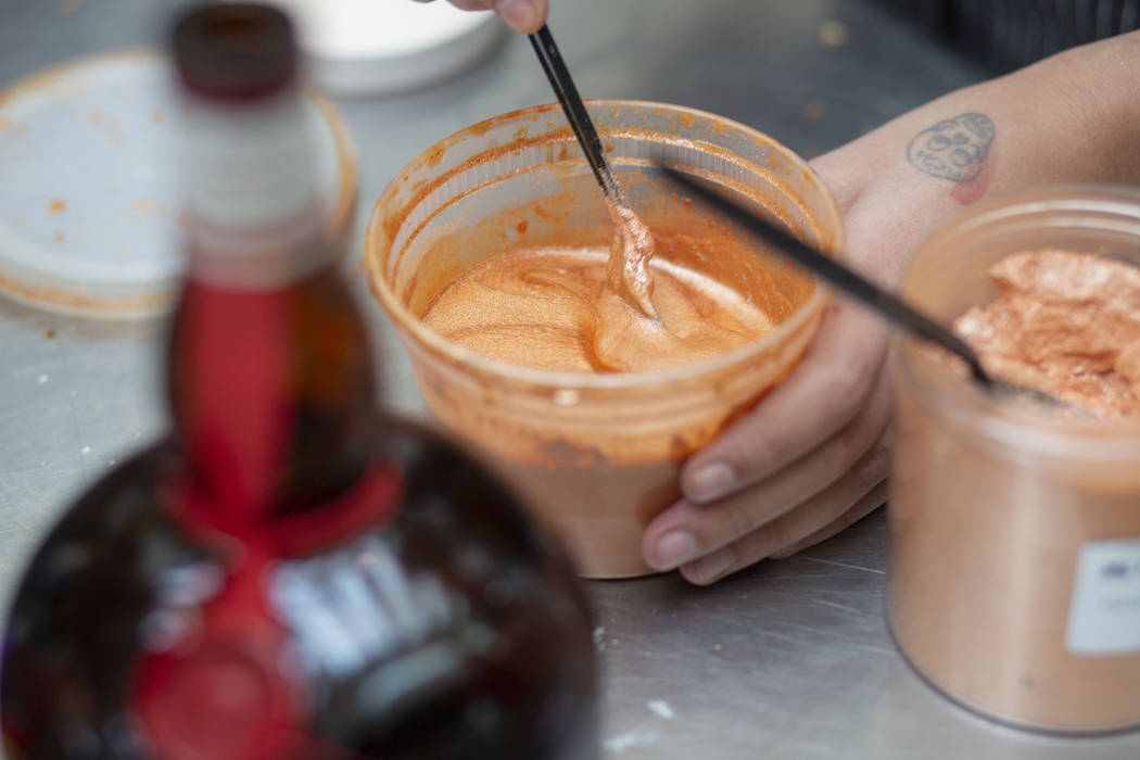 Aria Patisserie assistant pastry chef Andrea Madrid mixes liquor, and apricot luster to make a ...