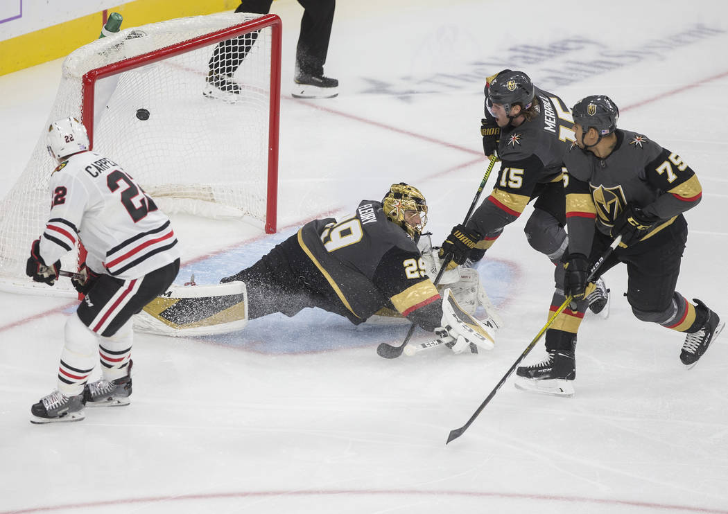 Chicago Blackhawks center Ryan Carpenter (22) watches a shot from teammate Kirby Dach (77) (out ...