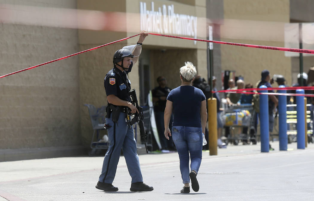 FILE - In this Aug. 3, 2019, file photo, an employee crosses into the crime scene following a s ...