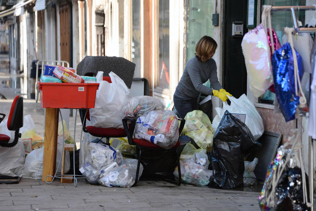 A woman cleans up following a flooding in Venice, Italy, Thursday, Nov. 14, 2019. The worst flo ...