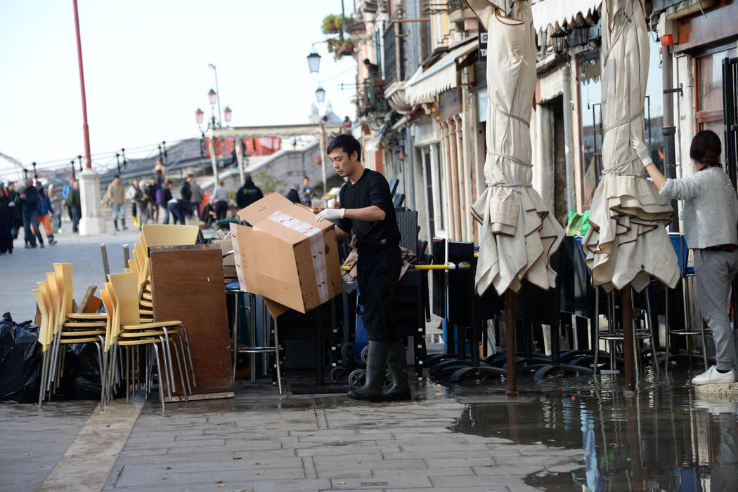 A man cleans up following a flooding in Venice, Italy, Thursday, Nov. 14, 2019. The worst flood ...