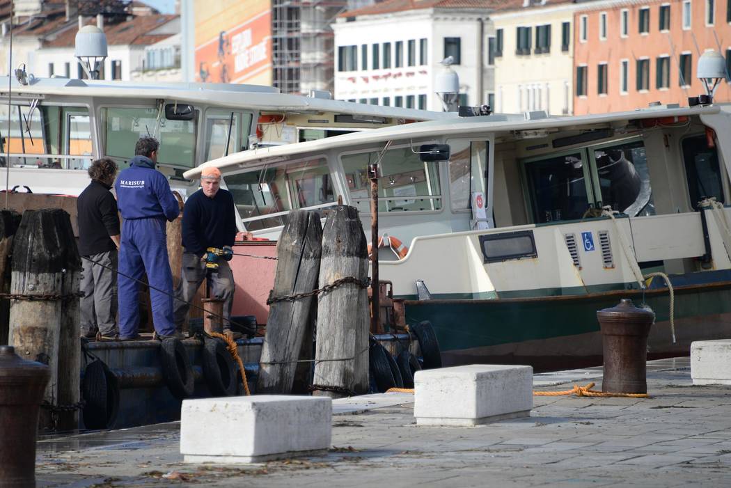 People work to fix damages following a flooding in Venice, Italy, Thursday, Nov. 14, 2019. The ...