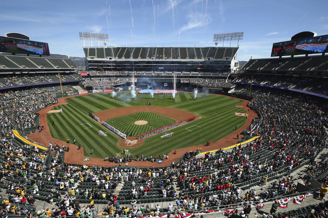 The Los Angeles Angels and the Oakland Athletics stand for the national anthem at Oakland Colis ...