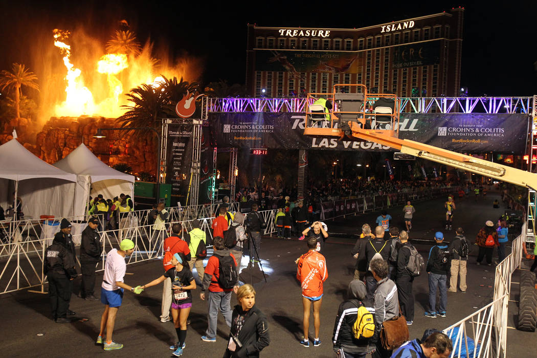 The Mirage volcano goes off as runners cross the half marathon finish line in the Las Vegas Roc ...