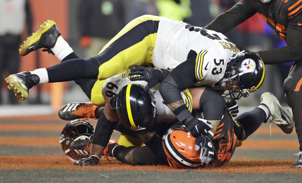 Cleveland Browns defensive end Myles Garrett, bottom, and, Pittsburgh Steelers center Maurkice ...