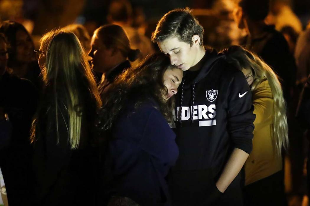 Hannah Schooping-Gutierrez, center, a student at Saugus High School, is comforted by her boyfri ...