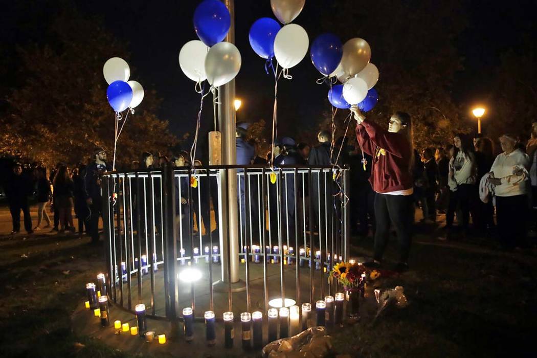 Jessica Dumont, a former student at Saugus High School, places balloons on a makeshift memorial ...