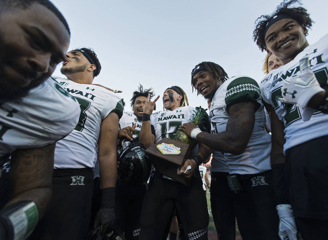 Hawaii Warriors quarterback Cole McDonald (13) celebrates with teammates after beating UNLV 21- ...