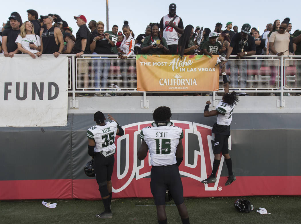 Hawaii Warriors defensive back Akil Francisco (23) celebrates with fans and teammates Paul Scot ...
