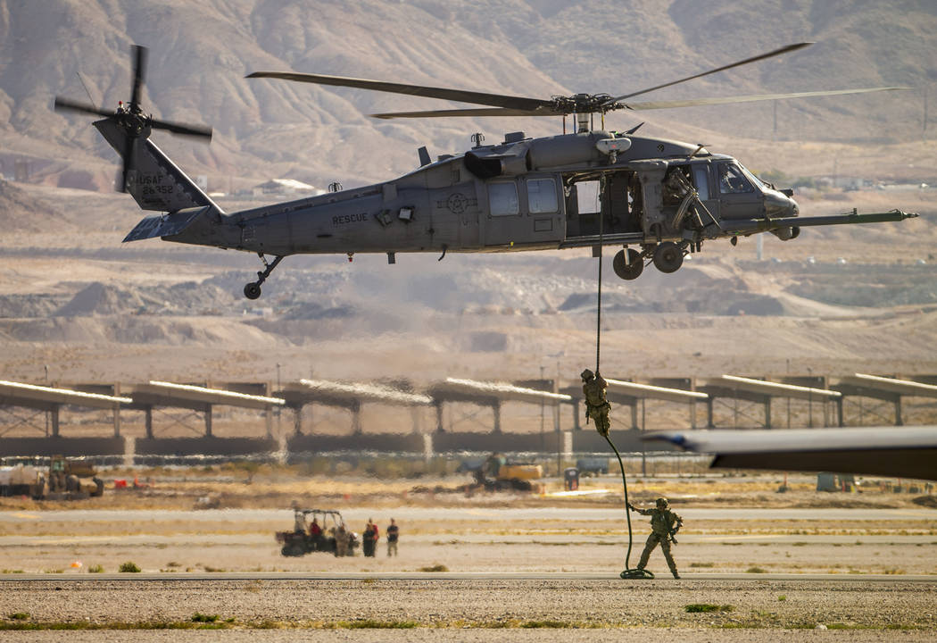 U.S. Air Force Pararescue members lower down onto the runway on a combined arms demo during the ...