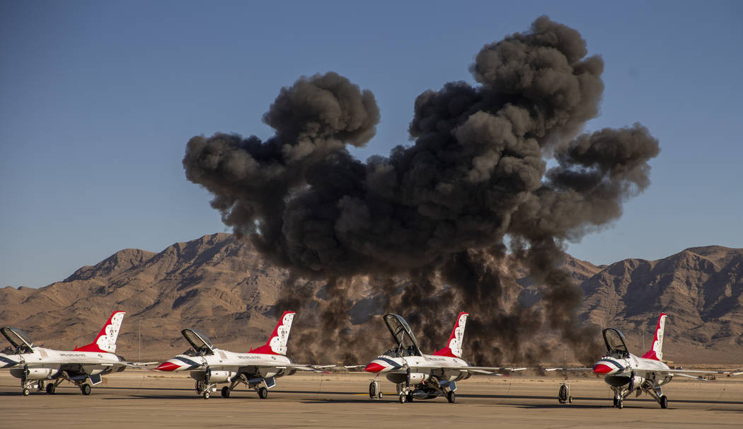 A mock explosion fills the sky with black smoke beyond the U.S. Air Force Thunderbirds during t ...