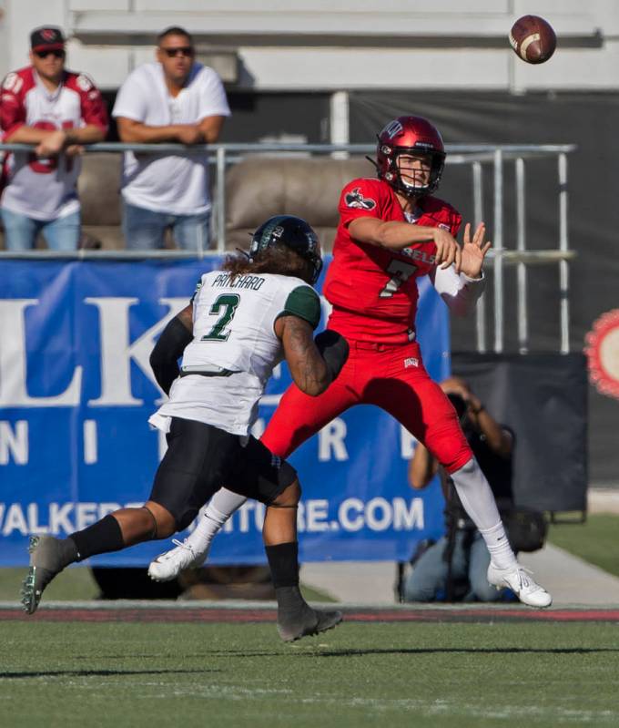 UNLV Rebels quarterback Kenyon Oblad (7) makes a throw on the run over Hawaii Warriors lineback ...