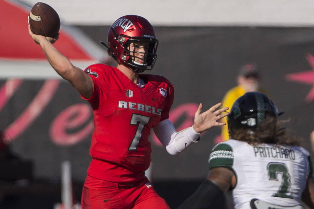 UNLV Rebels quarterback Kenyon Oblad (7) makes a throw on the run over Hawaii Warriors lineback ...