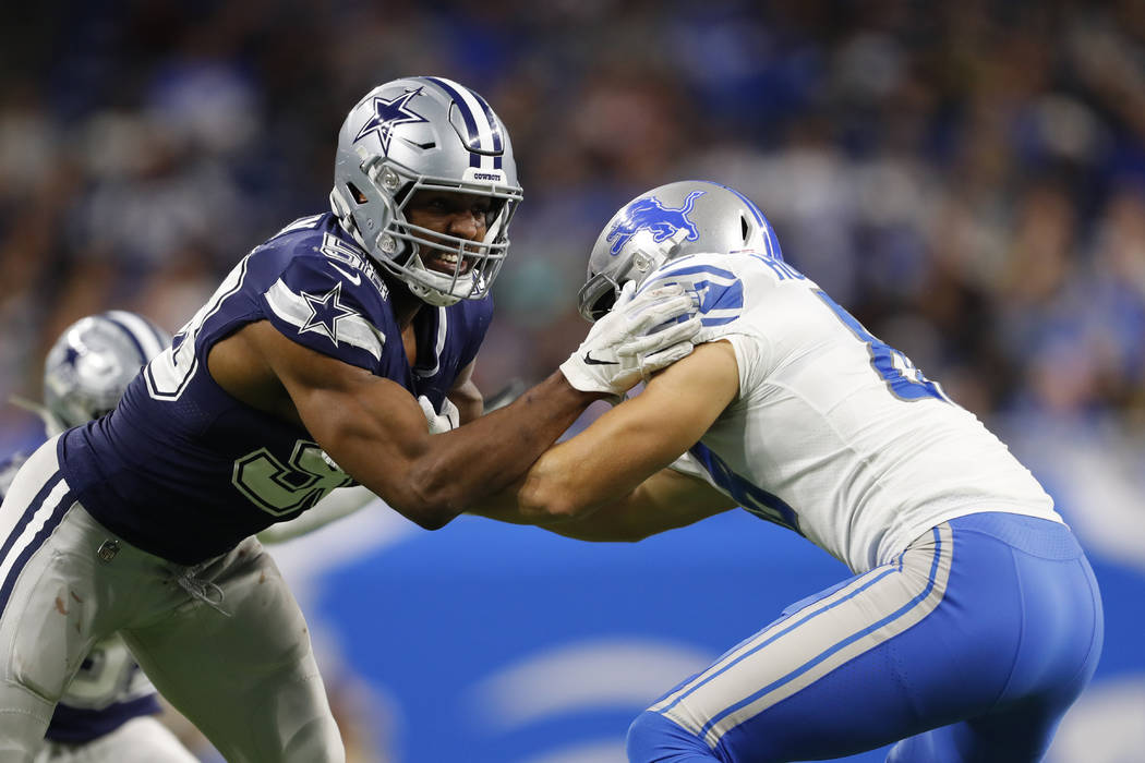 Dallas Cowboys defensive end Robert Quinn, left, goes up against Detroit Lions tight end T.J. H ...