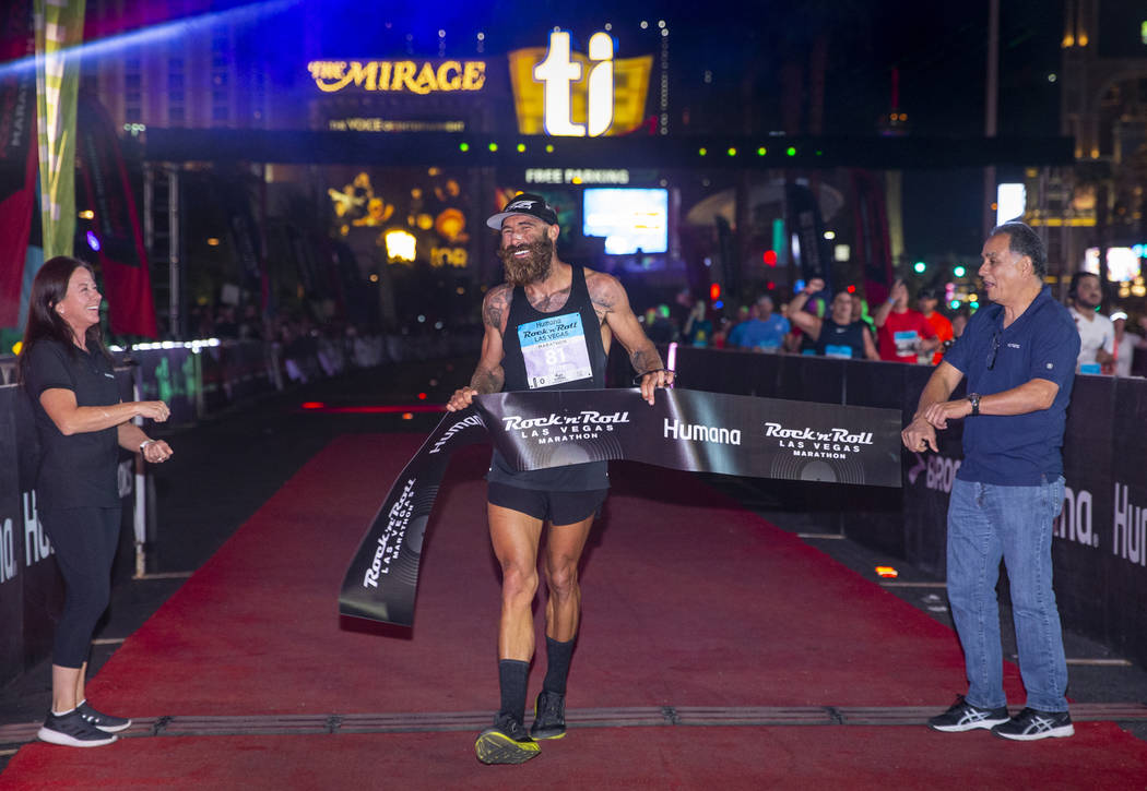 Men's marathon winner Tommy Puzey crosses the finish line during the Las Vegas Rock 'n' Roll Ma ...