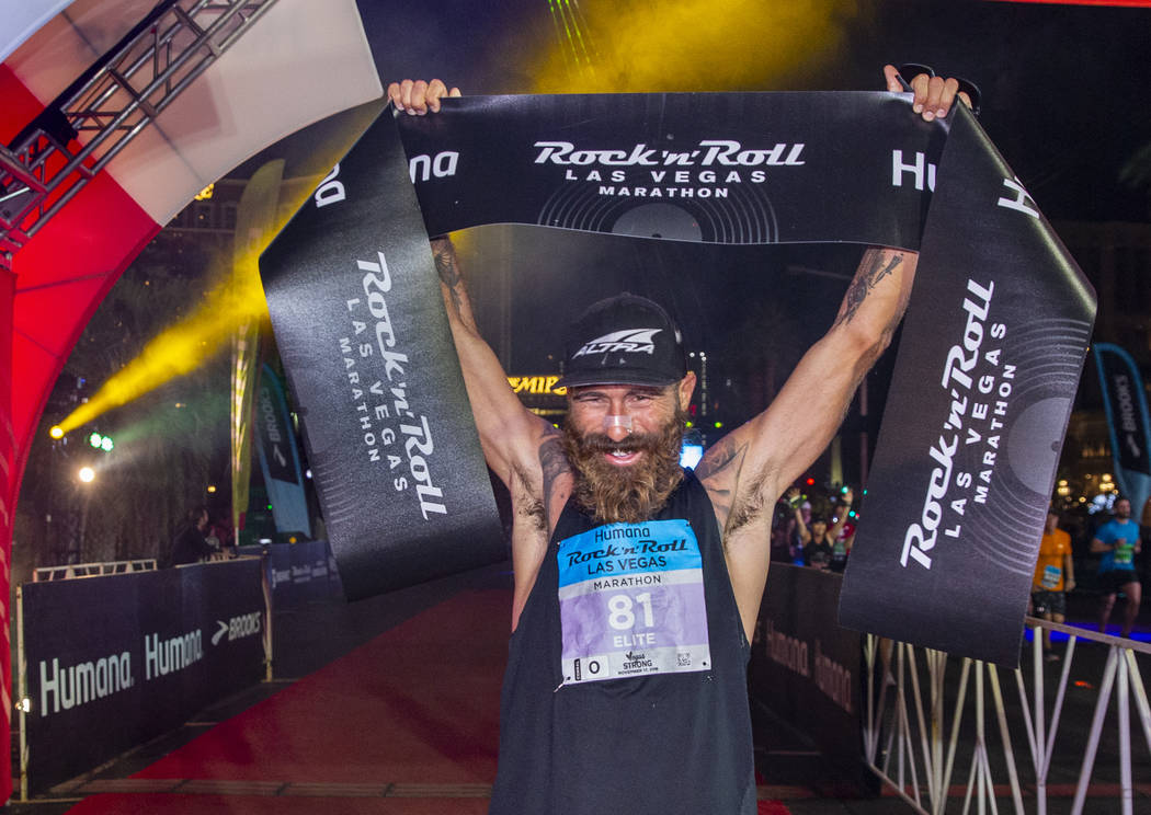 Men's marathon winner Tommy Puzey celebrates at the finish line during the Las Vegas Rock 'n' R ...