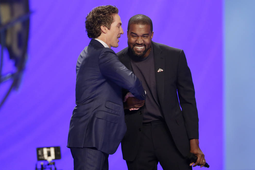 Rapper Kanye West, right, shakes hands with Joel Osteen during a service at Lakewood Church, S ...