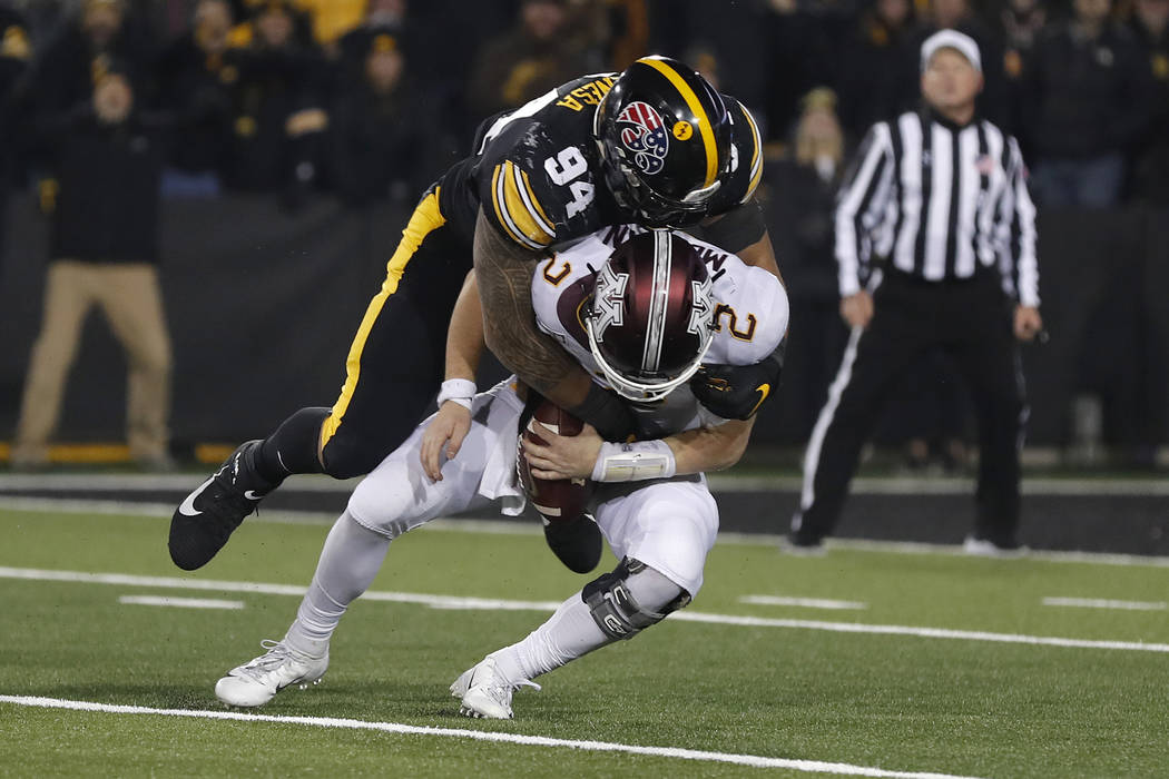 Iowa defensive end A.J. Epenesa, top, sacks Minnesota quarterback Tanner Morgan during the seco ...