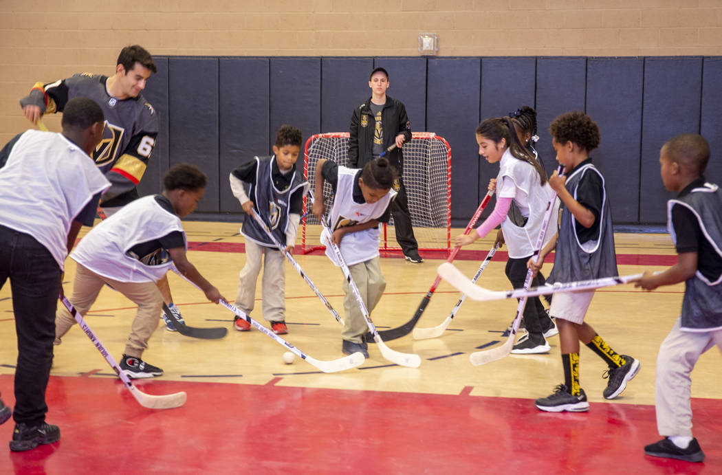 Kids at the Doc Pearson Community Center play street hockey during a street hockey clinic hoste ...