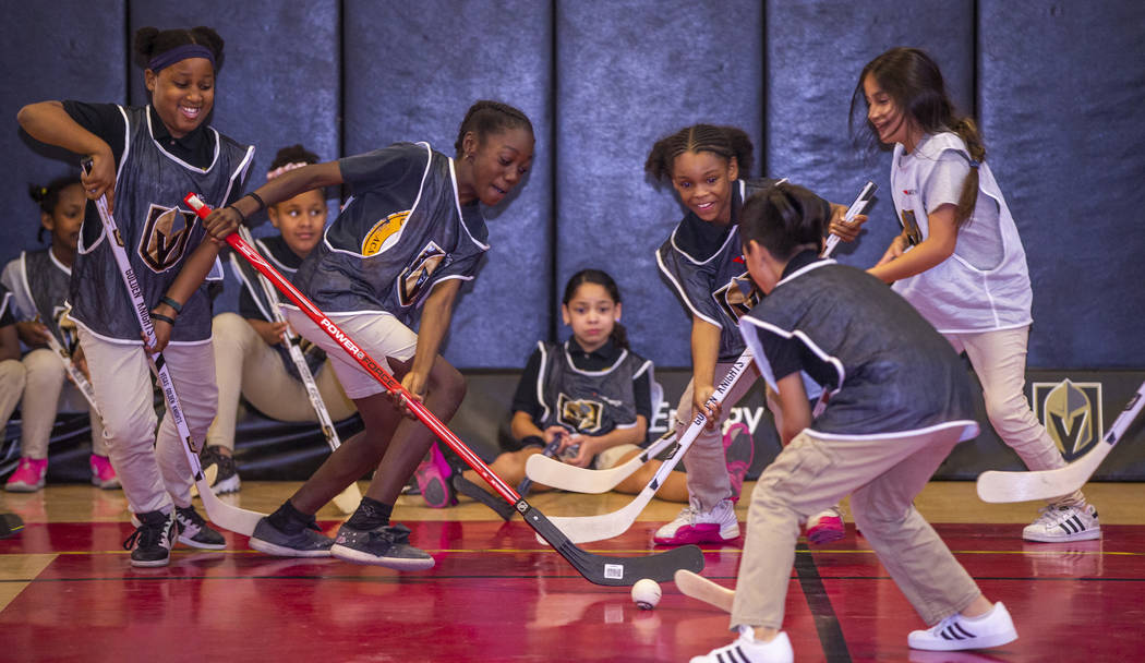 Kids at the Doc Pearson Community Center play street hockey during a street hockey clinic hoste ...