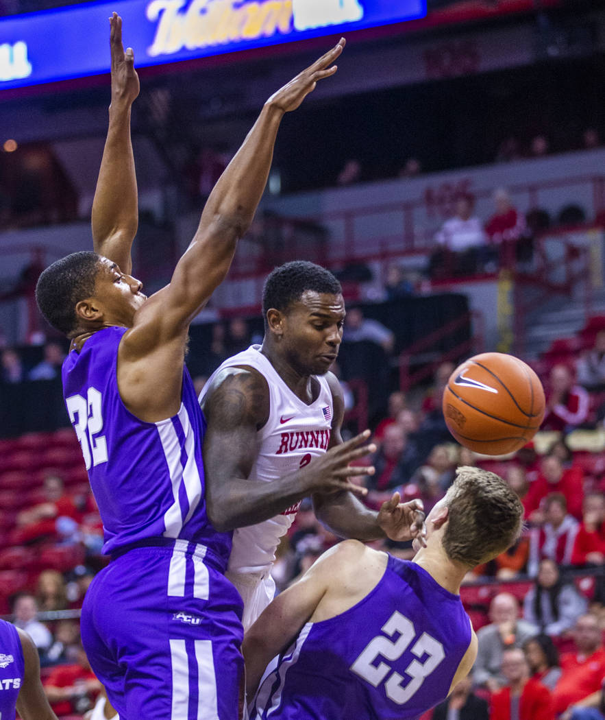 UNLV Rebels guard Amauri Hardy (3, center) is fouled on the drive by Abilene Christian Wildcats ...
